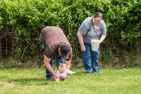 Mom holds the bucket while dad offers his assistance